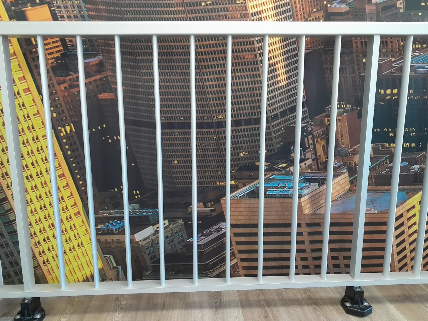 Barandilla de aluminio lacado con barrotes verticales y panel instalada en un balcón
