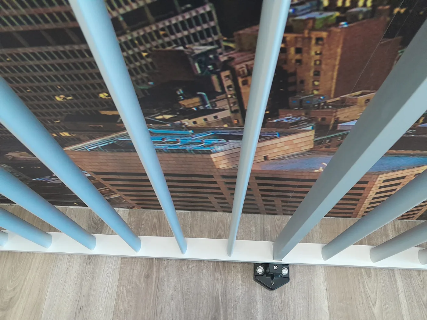 Detalle de la base y los montantes de una barandilla de aluminio sobre el pavimento de una terraza