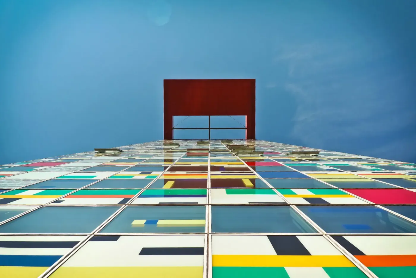 Façana de vidre amb panells de colors vius, exemple de cromatisme arquitectònic a prop de Girona