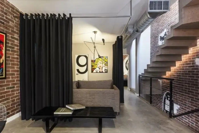 Porta i divisió de vidre d'estil crittall amb retícula negra entre la sala i la cuina d'un pis a Girona