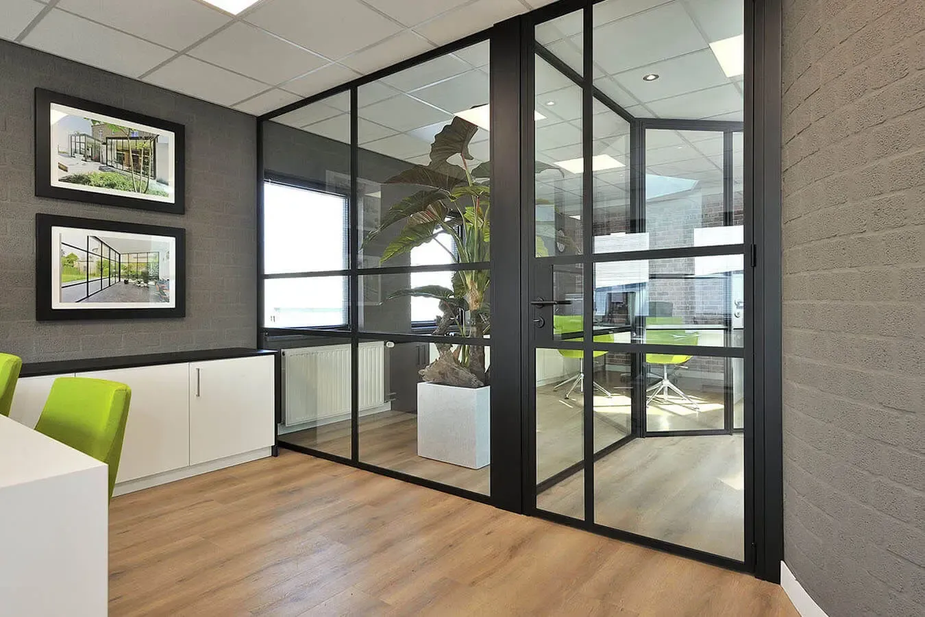 Espai obert amb divisions de vidre i perfils negres que connecten ambients sense perdre llum en un interior contemporani a Girona