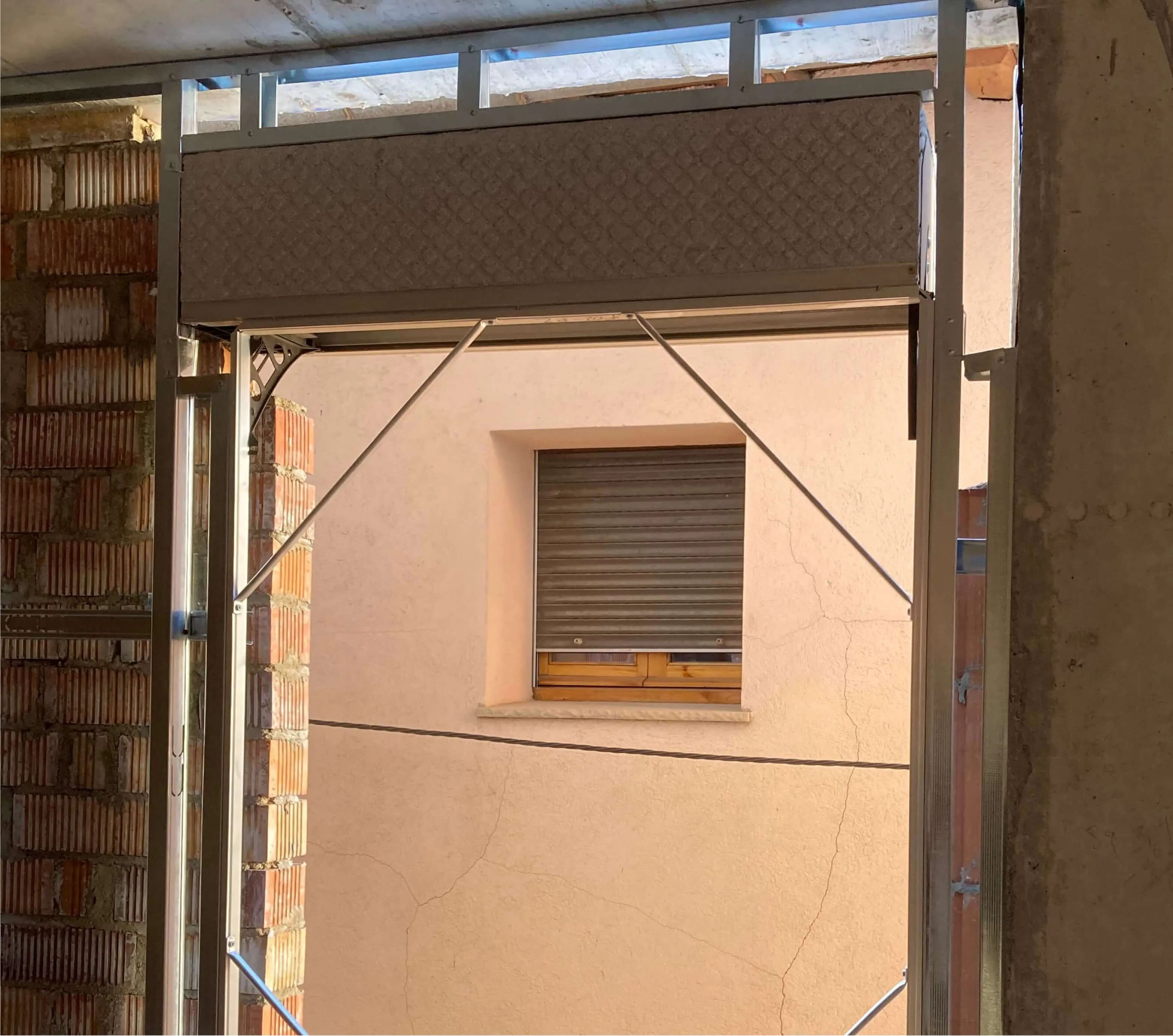Cajón COMPACTBOX instalado en la cabeza del hueco de una puerta balconera en una obra de rehabilitación