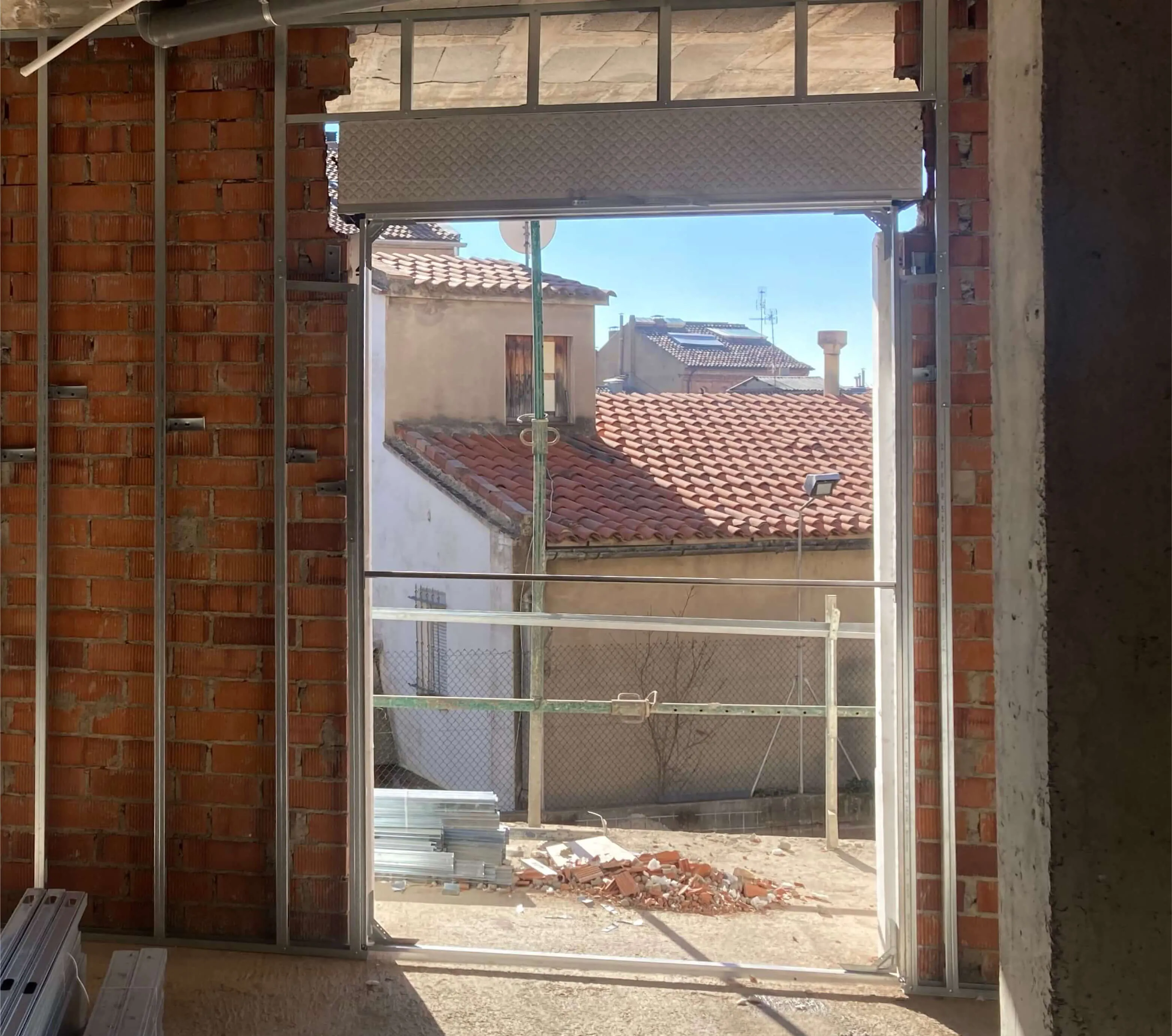Cajón de persiana COMPACTBOX colocado en un hueco de ventana con vistas al exterior durante la obra