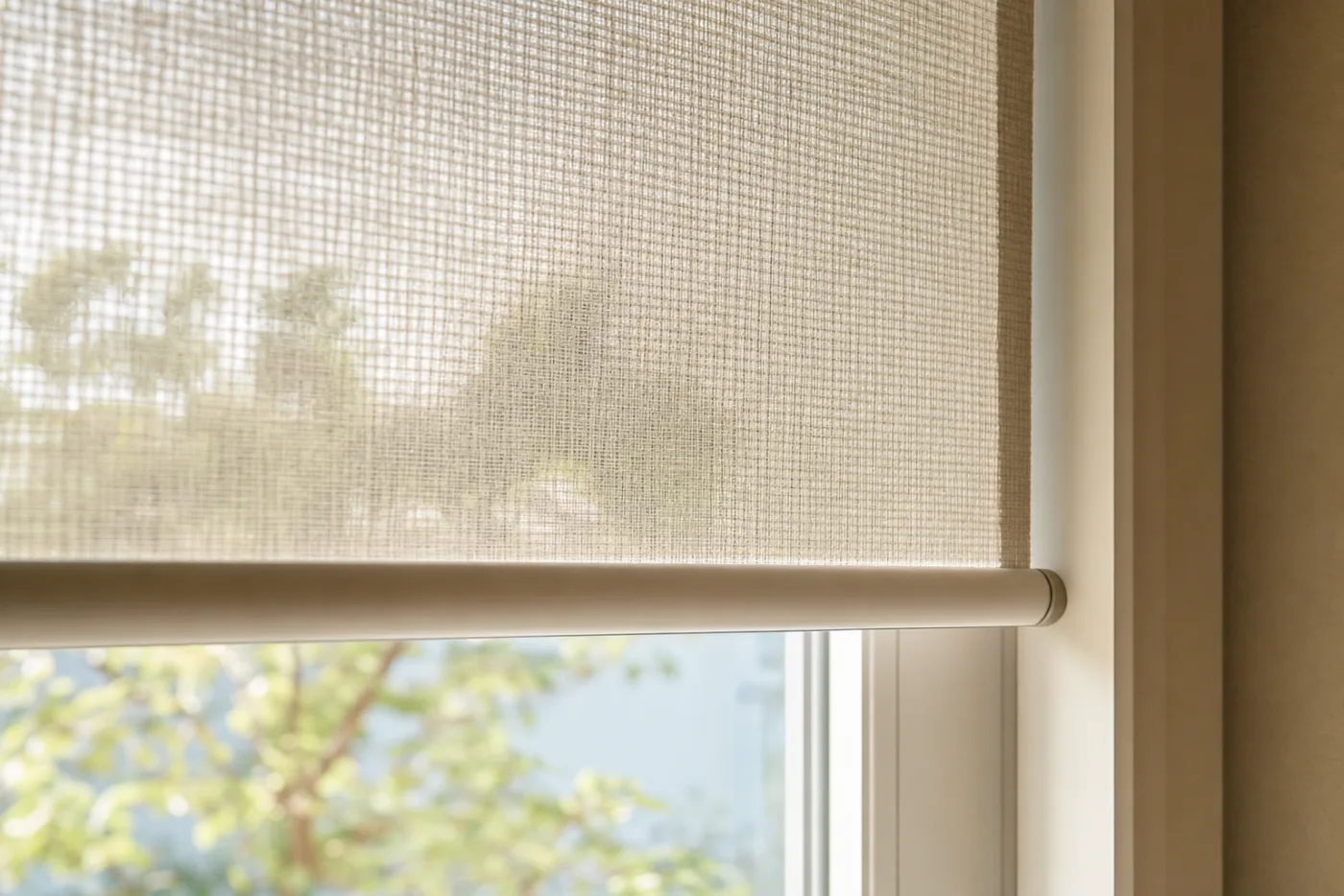 Detall del teixit screen microperforat d'un estor que filtra la llum del sol mantenint les vistes