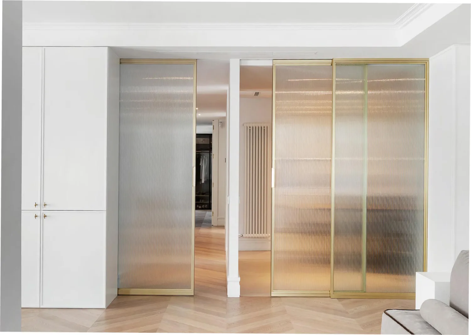 Porta corredissa interior de perfil daurat amb vidre estriat reeded del sistema IDAdoor