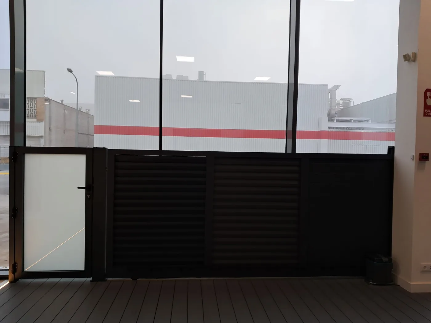 Cancela corredera de aluminio oscuro con portillo peatonal instalada por Finestres Girona