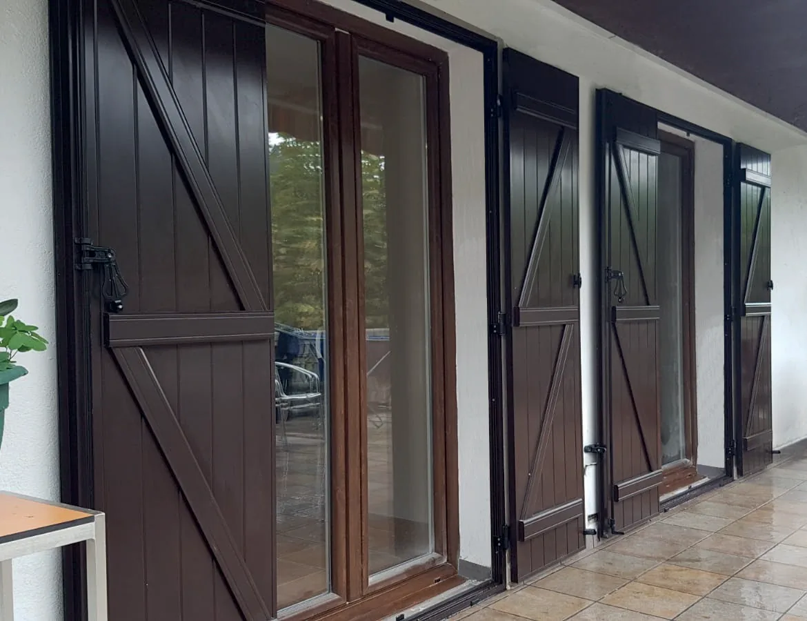 Porticons exteriors marrons amb trancas instal·lats en un porxo