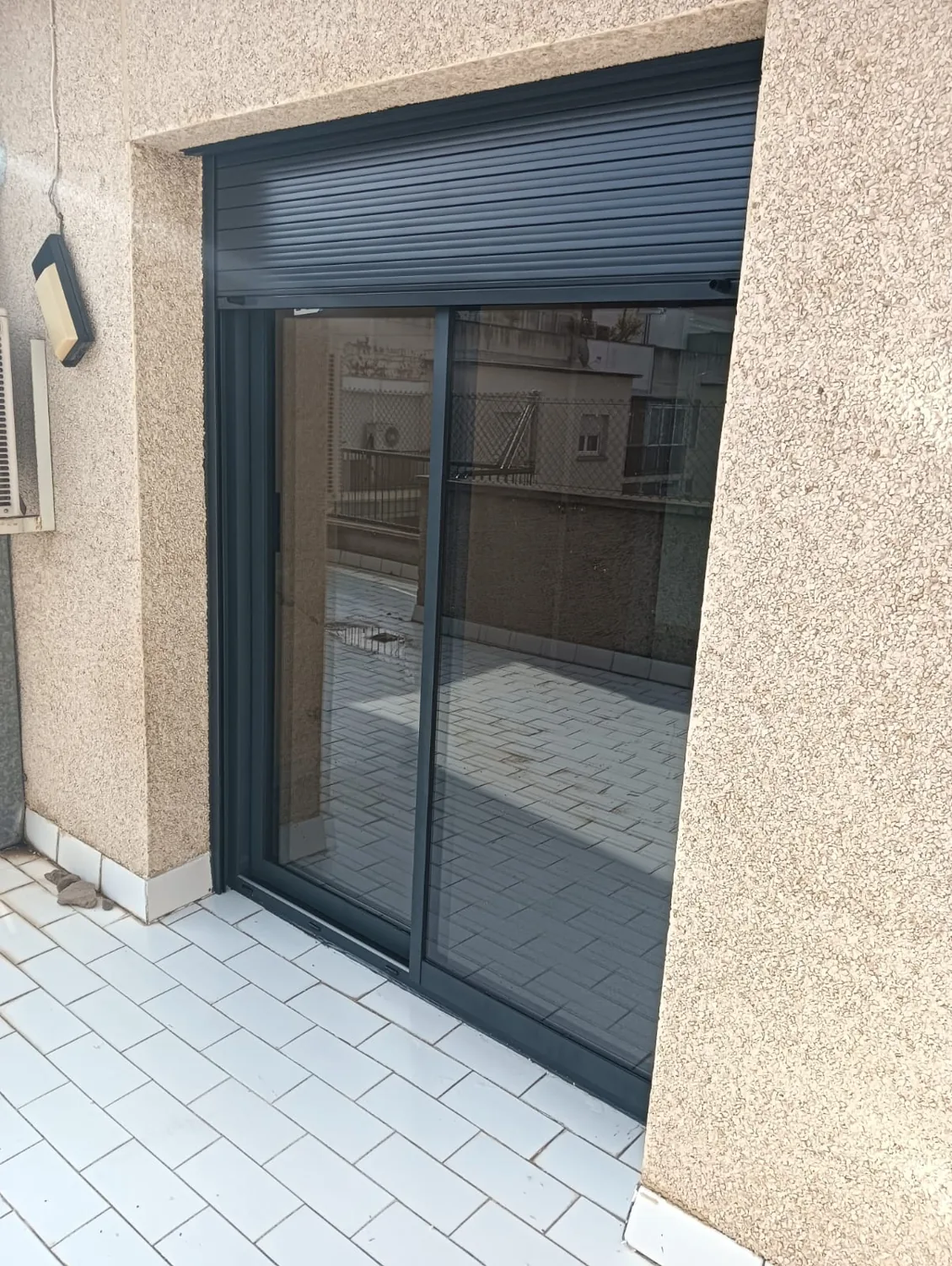 Correderas de aluminio antracita con persiana en un ático