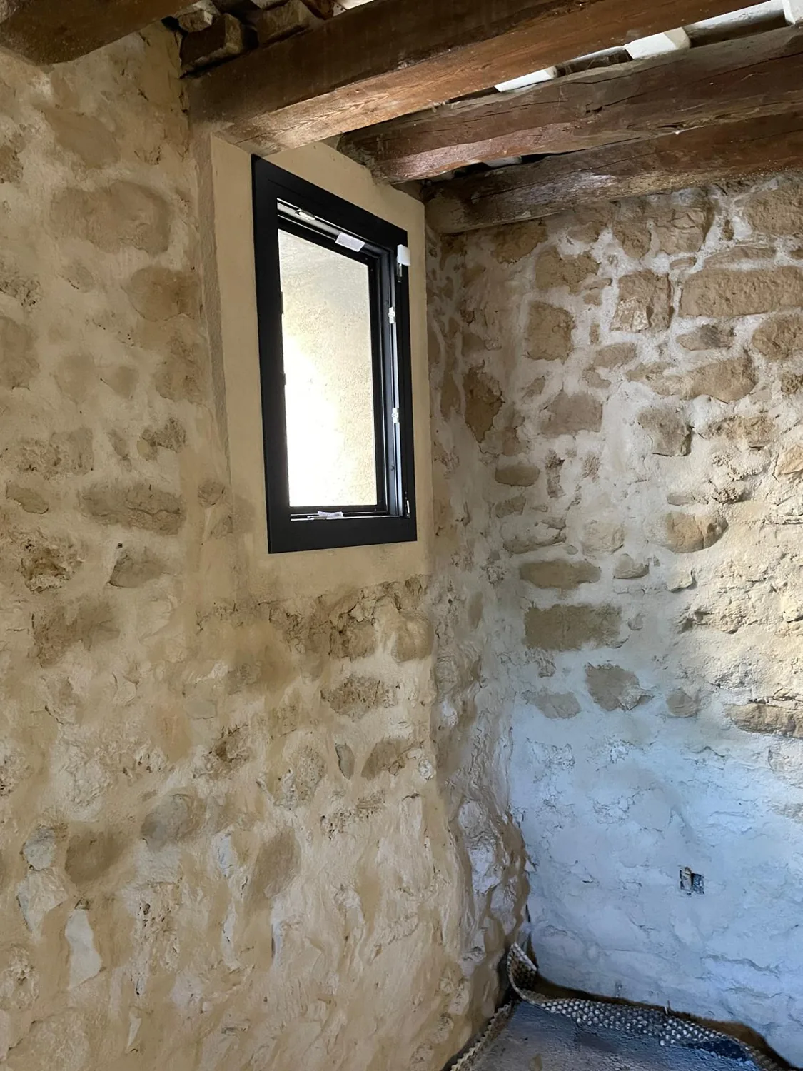 Ventanas de aluminio negro en una masía de piedra