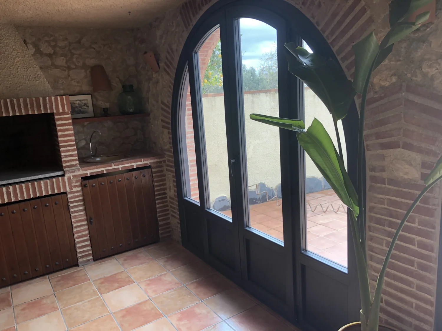 Ventanales en arco de PVC antracita en una masía de piedra