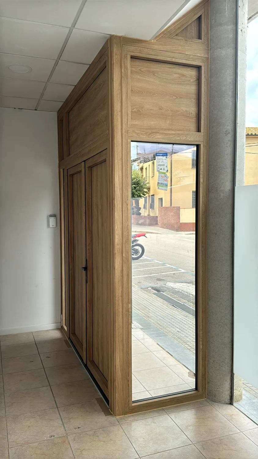 Puerta de entrada de aluminio imitación madera para local comercial