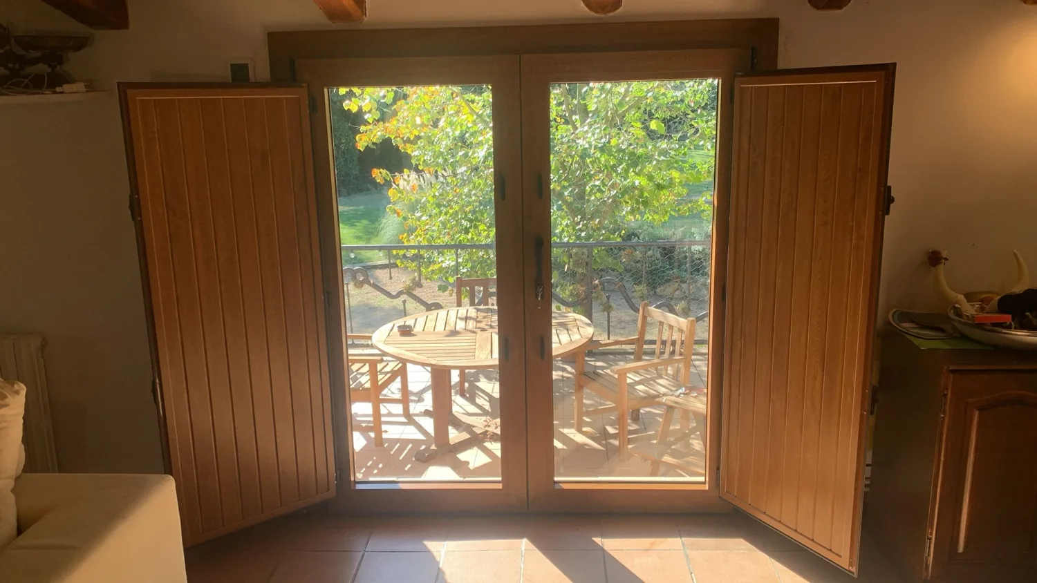 Portes i balconeres de PVC imitació fusta en una masia de pedra (2)