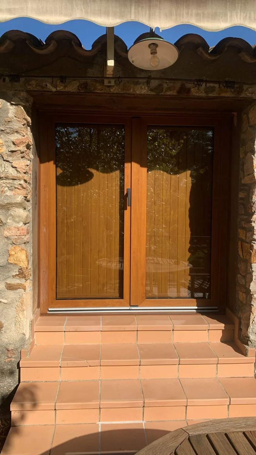 Portes i balconeres de PVC imitació fusta en una masia de pedra (6)