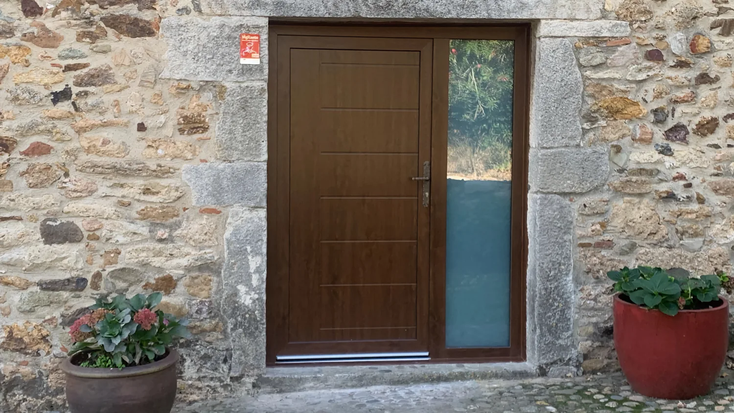 Portes i balconeres de PVC imitació fusta en una masia de pedra (8)