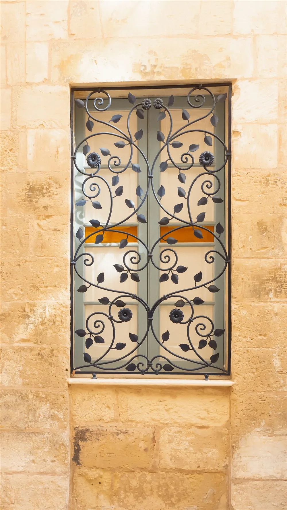 Reixa de ferro forjat decorativa amb volutes i motius florals