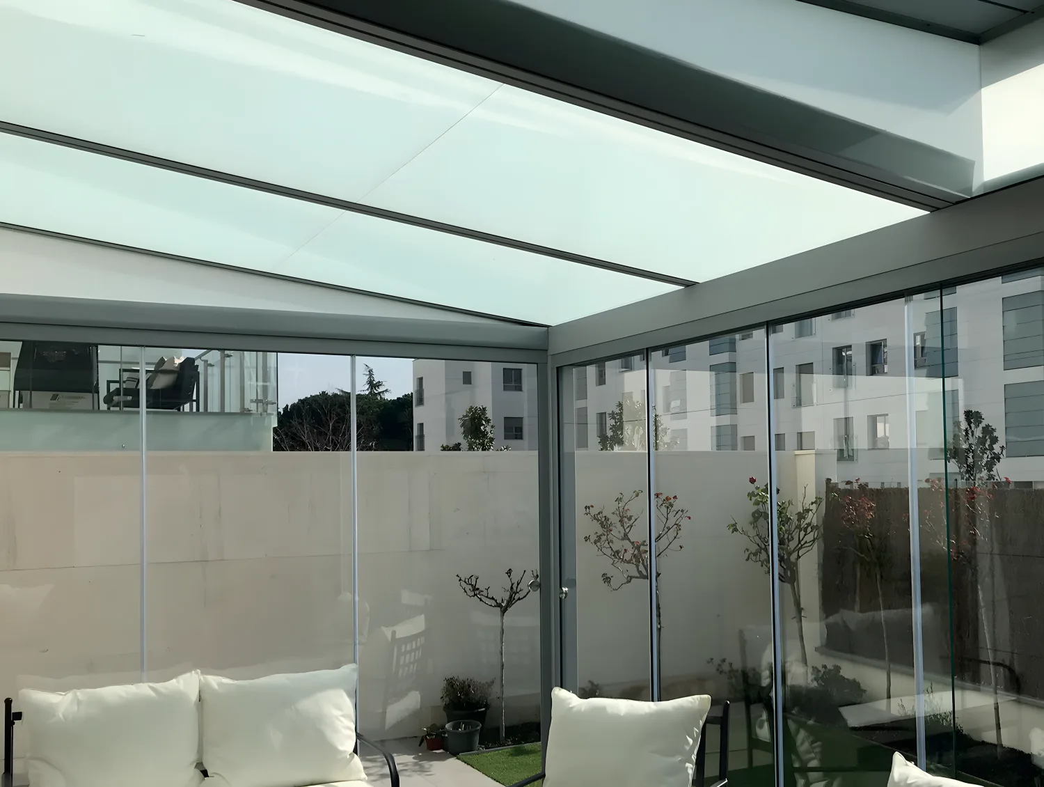 Galería con techo de cristal y cortinas de cristal perimetrales