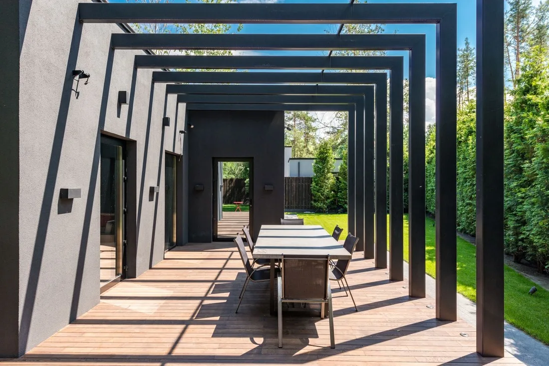 Pérgola de aluminio con techo acristalado sobre una terraza de madera