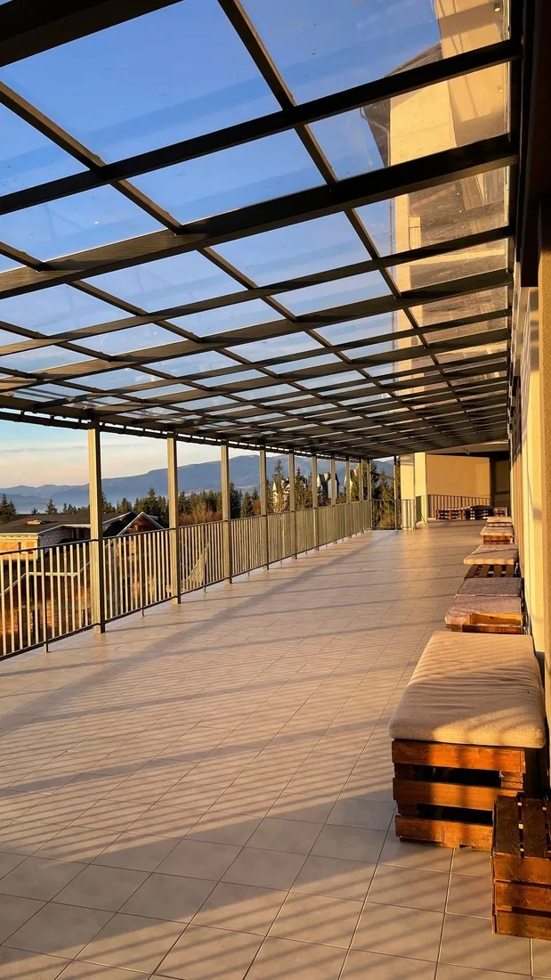 Techo fijo de cristal sobre una terraza con barandilla y vistas