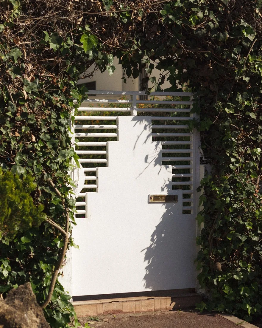 Porta peatonal d'alumini lacat blanc de disseny modern amb bústia