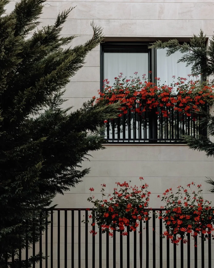 Tanca d'alumini de barrots verticals en color negre amb flors