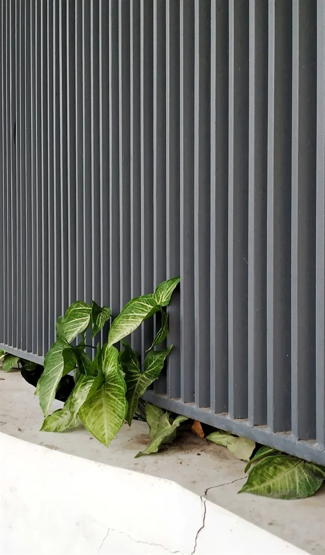 Detall d'una tanca d'alumini de lamel·les verticals en gris antracita